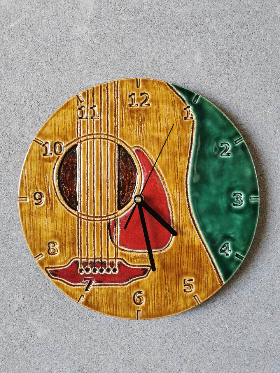 Ceramiczny ręcznie wykonany zegar w kolorze bursztynu i butelkowej zieleni z gitarą klasyczną dla muzyka.