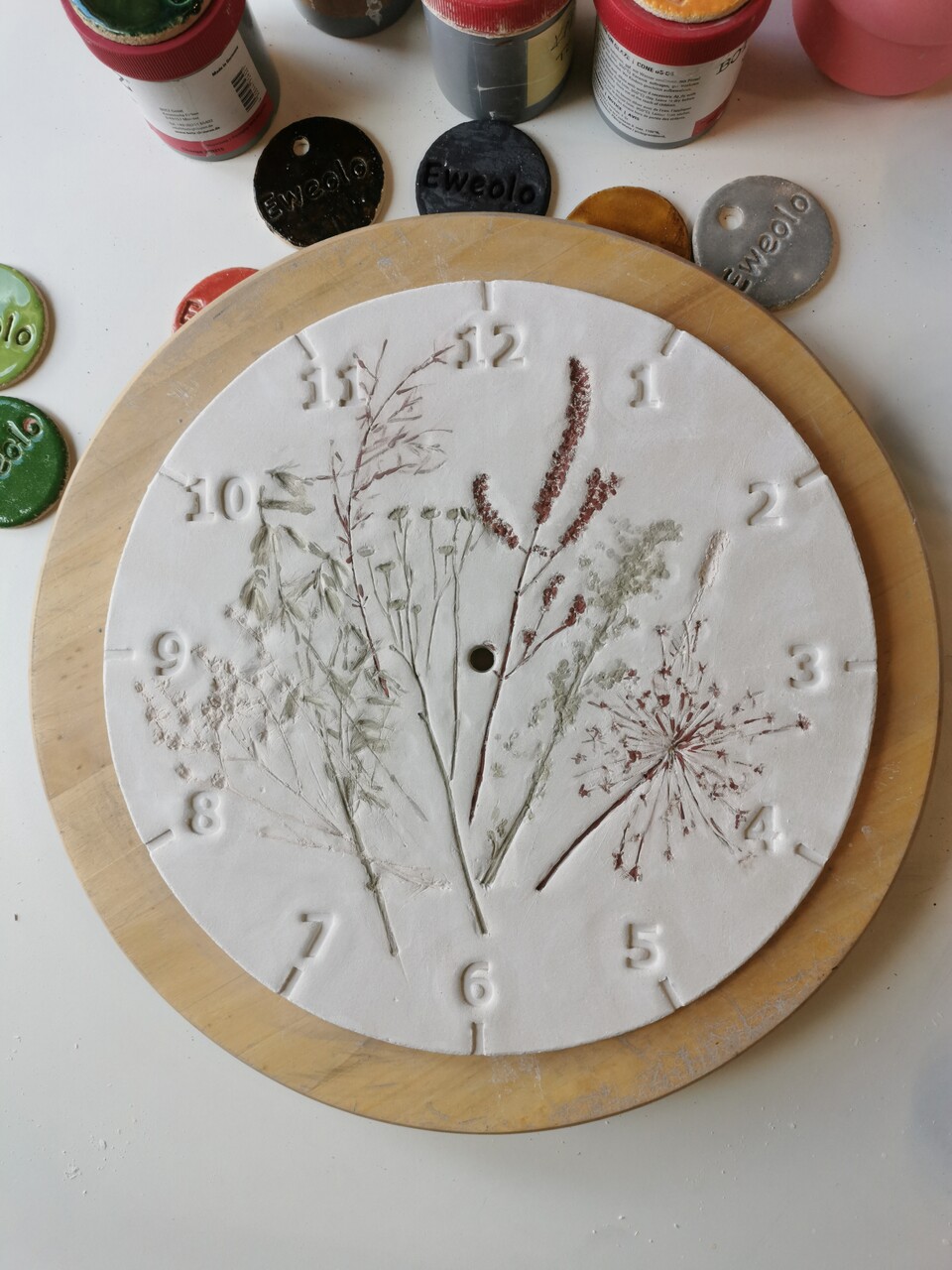 Tarcza zegara Polne Skarby pokryta szkliwem przed wypałem – etap tworzenia rękodzieła ceramicznego.