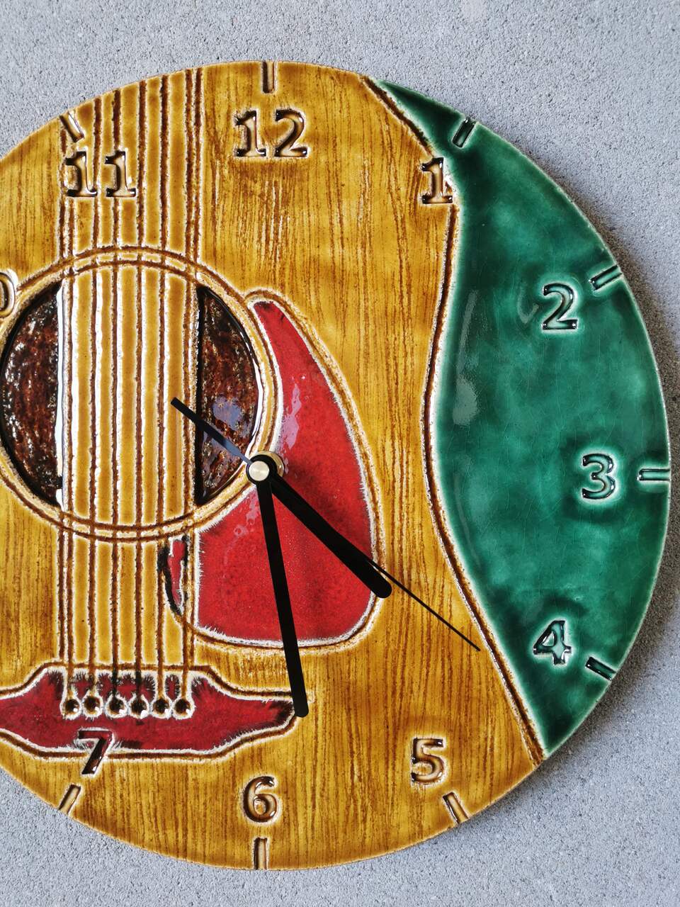 Unikatowy zegar z gliny z motywem korpusu gitary klasycznej.