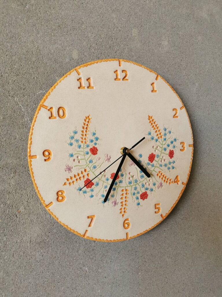 Widok boczny na ścianie zegara wianek zbóż i polnych kwiatów – rękodzieło w stylu rustykalnym i boho.