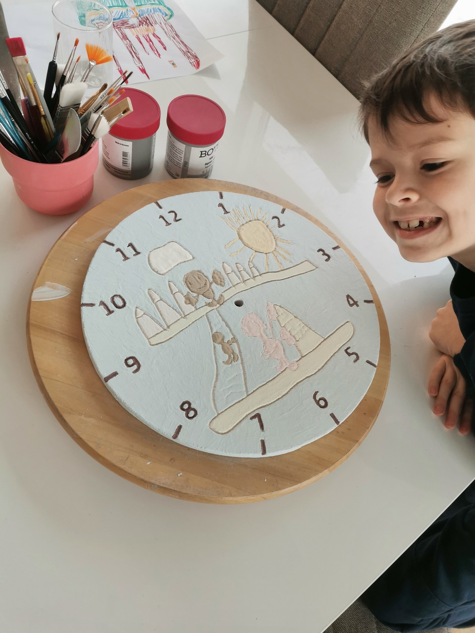 dziecięcy ceramiczny zegar przed wypałem koloru w pracowni wraz z autorem pracy