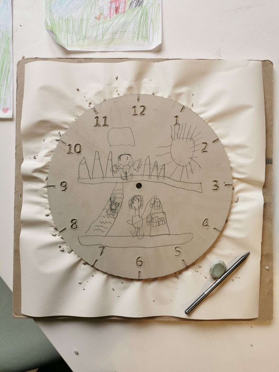 proces przenoszenia rysunku dziecka na glinę, ręcznie lepiony zegar ceramiczny