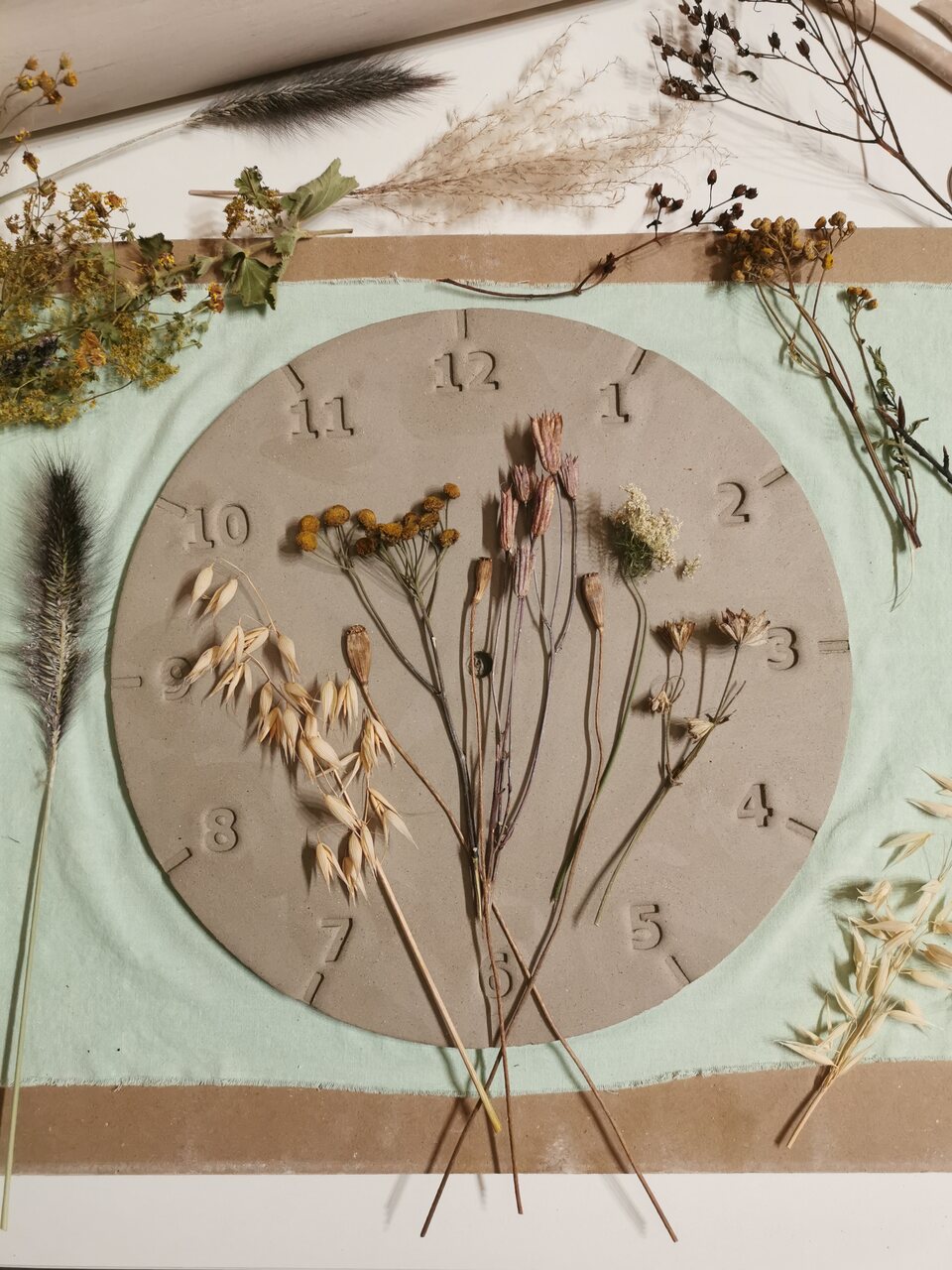 odciskanie kwiatów na glinie - ceramiczny zegar na zamówienie