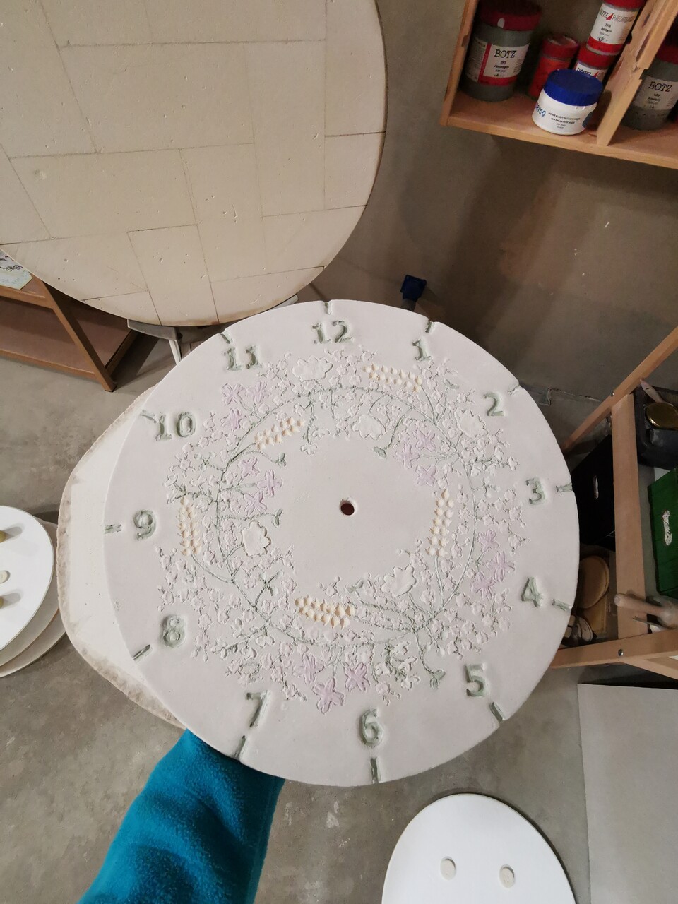 Sucha tarcza zegara przed wypałem w piecu ceramicznym.