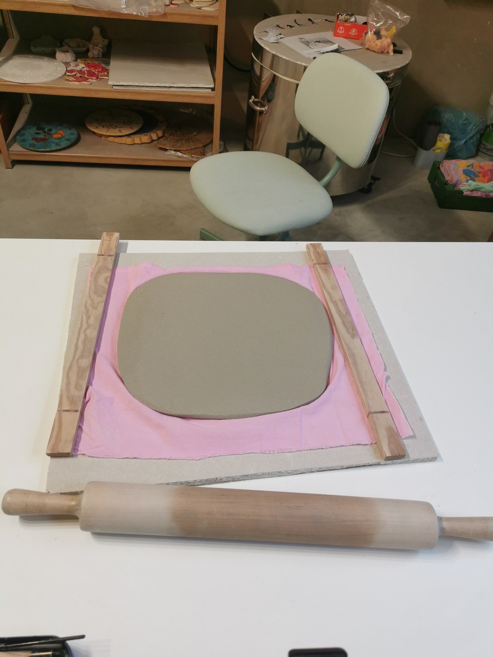 Etap formowania z gliny tarczy, na której powstanie niebieski zegar w ludowe kwiaty.