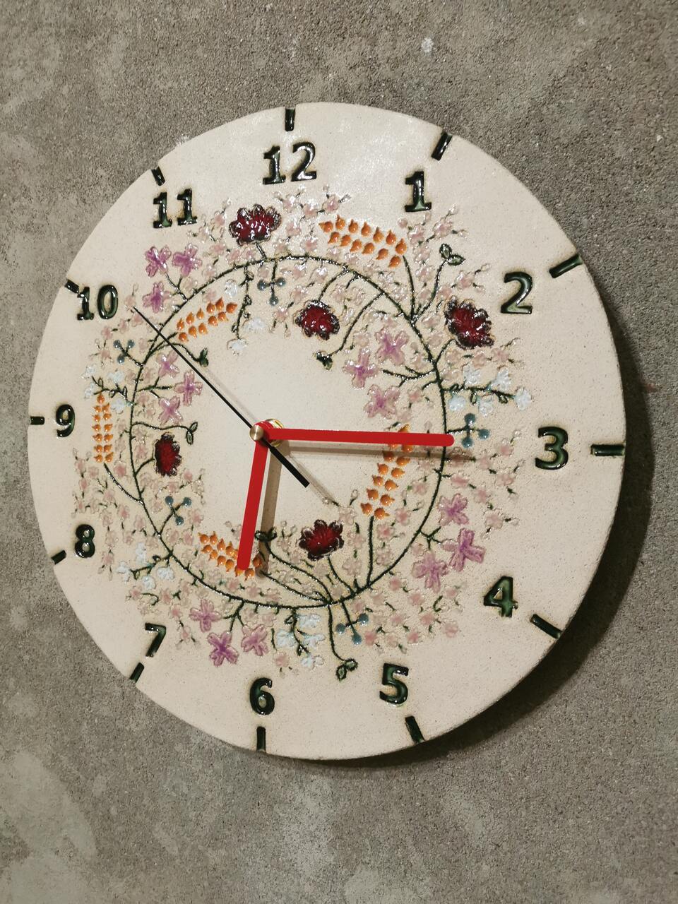 Widoczna bogata tekstura i subtelne szkliwienie ceramicznego zegara kwietnego.