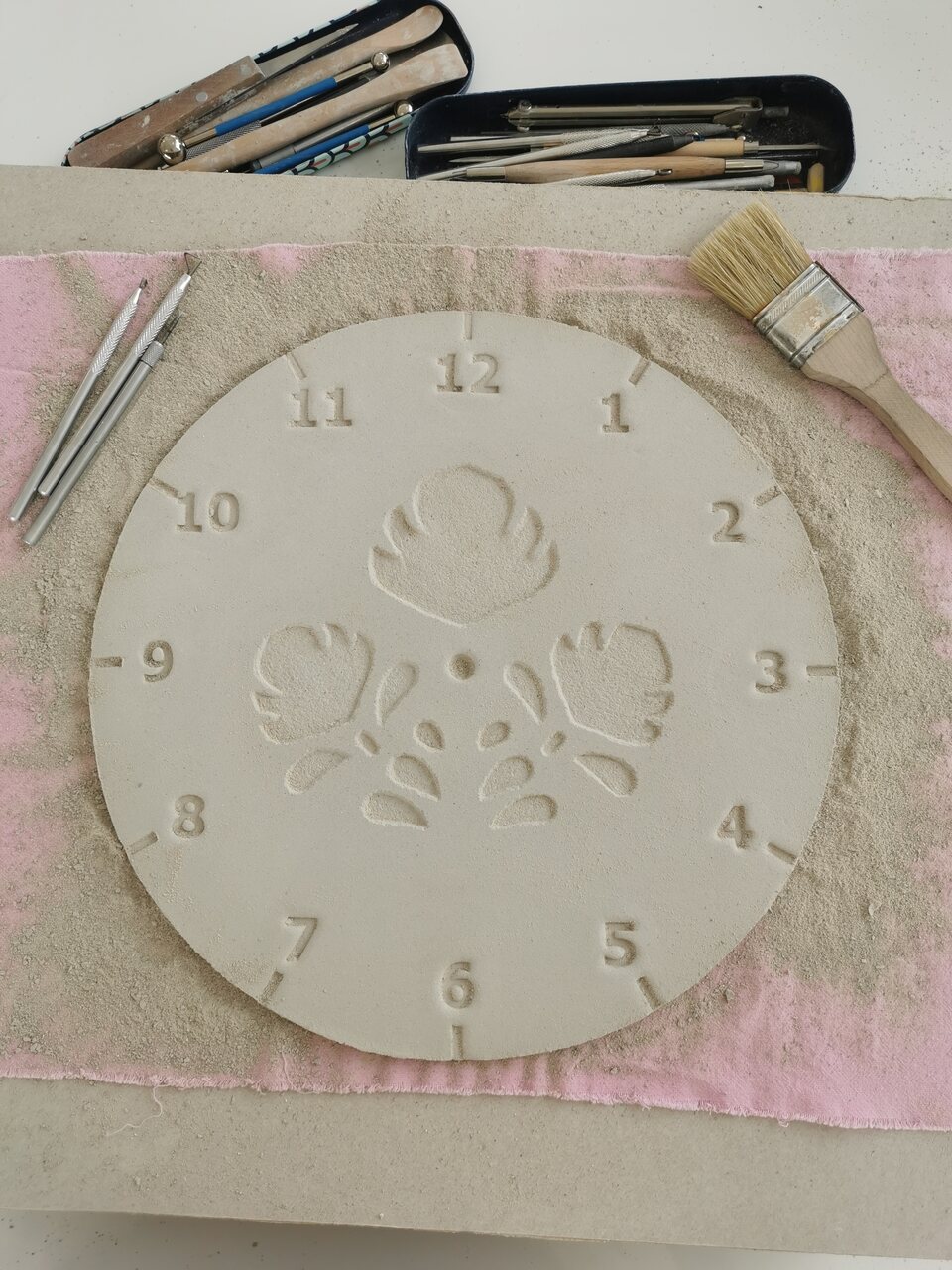 Wydłubany ręcznie wzór ludowych kwiatów na glinie - zdjęcie z pracowni.