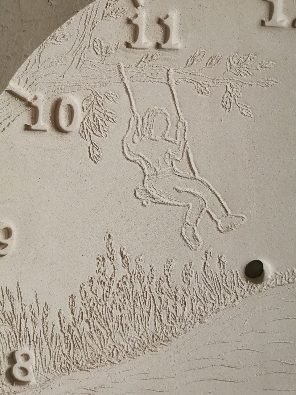 Detal na ceramicznym zegarze na prezent na rocznicę - mama na huśtawce