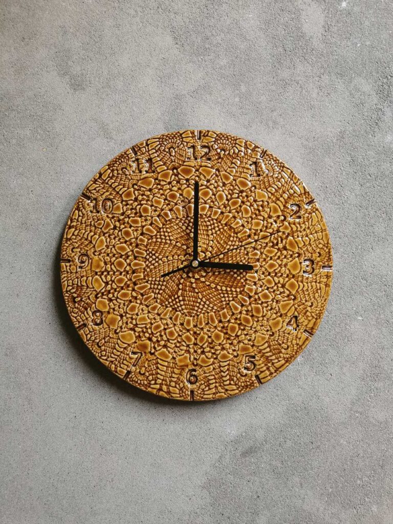 Ręcznie robiony zegar ceramiczny Kwiat Czasu w kolorze koniakowym. Okrągła tarcza z gliny pokryta błyszczącym, bursztynowym szkliwem o unikalnej strukturze.