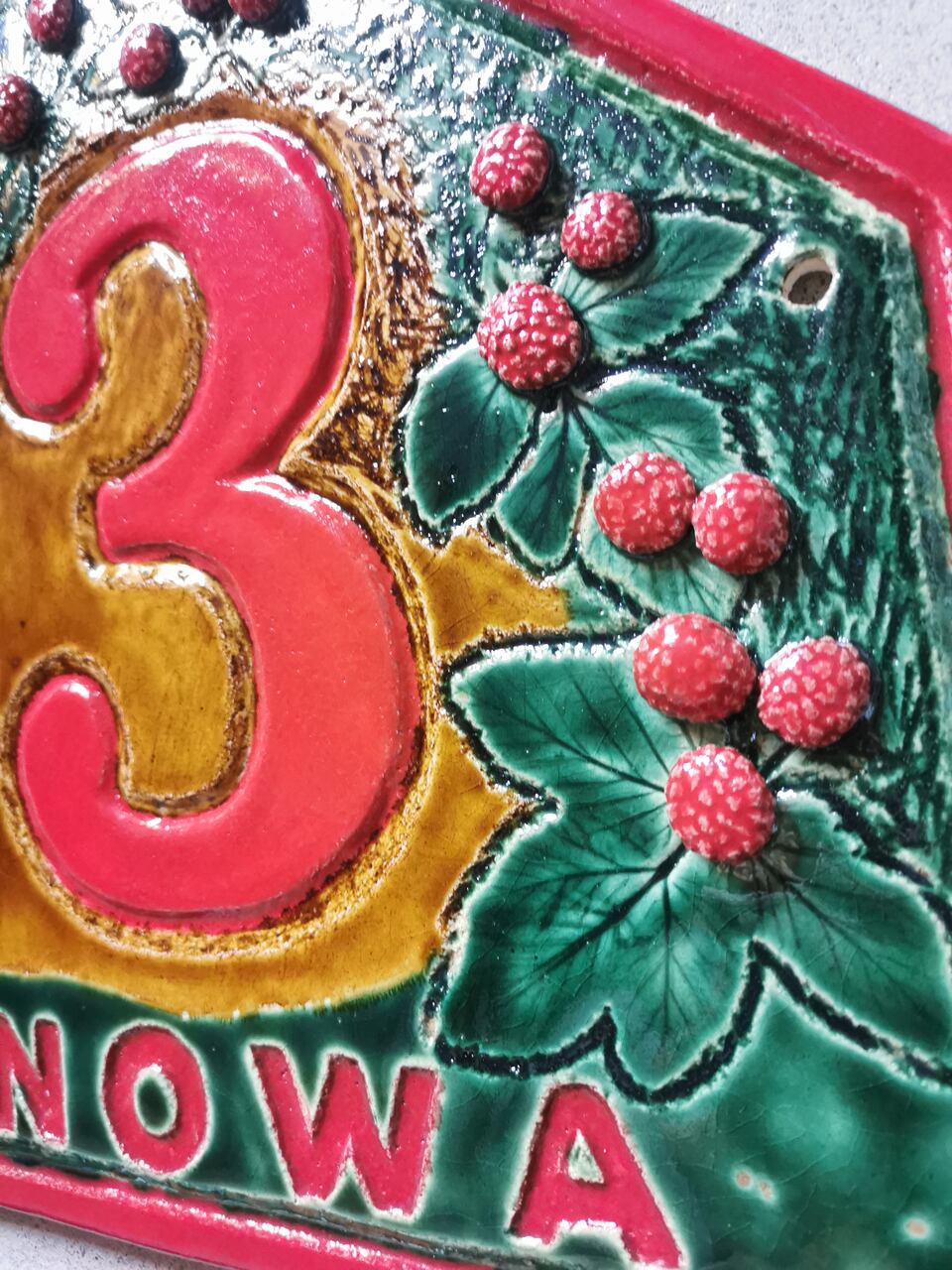 Trójwymiarowy wzór malin na ceramicznej tabliczce adresowej na zamówienie wykonananej.