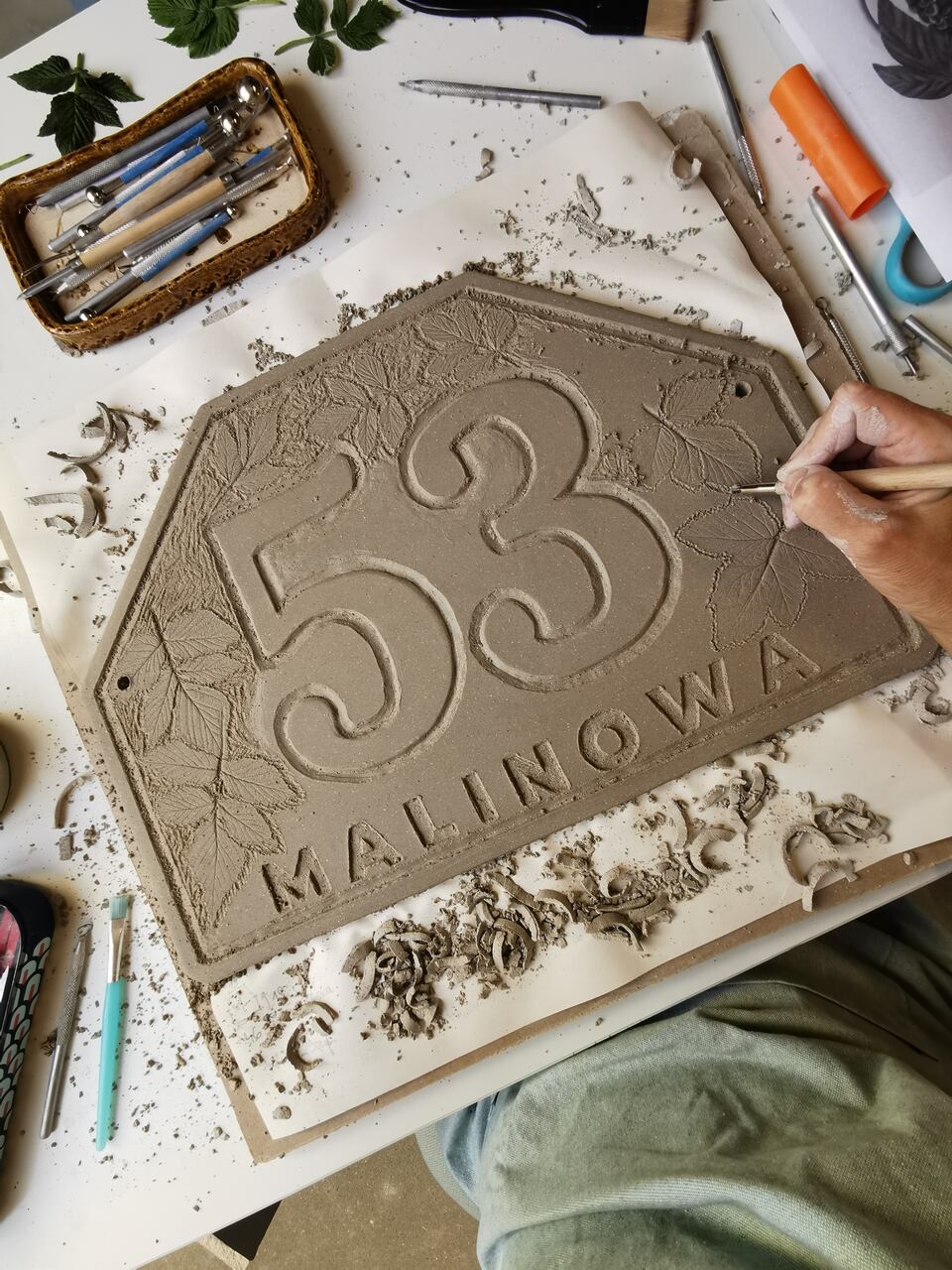 Proces tworzenia ceramicznej tabliczki adresowej na zamówienie.