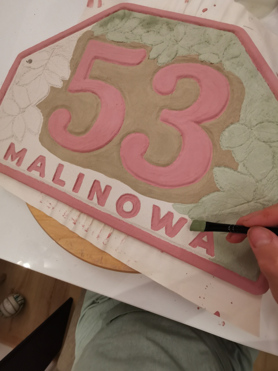 Ręczne malowanie numeru na dom z ceramiki.