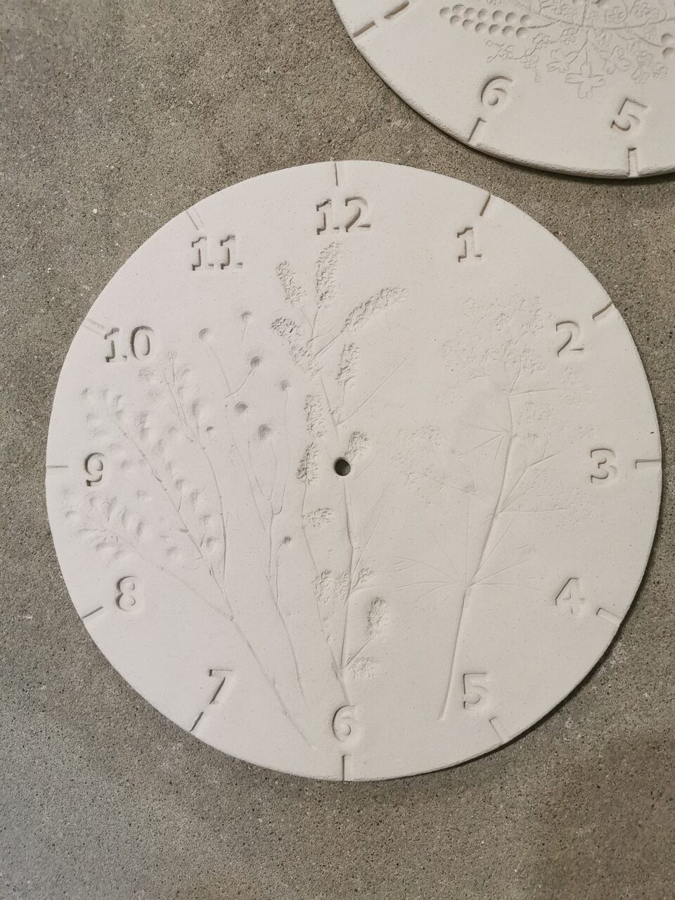 Ceramika po wypale wpiecu będąca ręcznie wykonaną tarczą ceramicznego zegra ściennego na zamówienie.